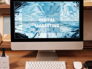 Apple Monitor with digital marketing on screen sitting on a wooden desk